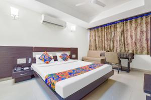 a bedroom with a bed and a desk in a room at FabHotel Skyland in Ahmedabad