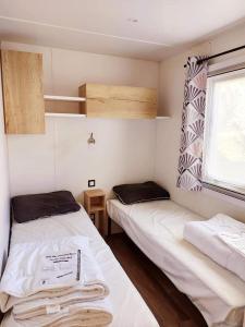 レ・マトゥにあるBora Bora les Mathesの窓付きの小さな部屋のベッド2台