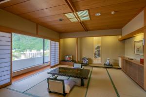 a living room with a table and a window at Kinugawa Grand Hotel Yumenotoki in Nikko