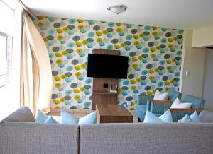 - un salon avec un canapé et une télévision dans l'établissement 56 Oceanic Holiday Apartment, à Durban