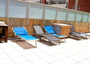 - un ensemble de chaises et d'une table sur une terrasse dans l'établissement 56 Oceanic Holiday Apartment, à Durban
