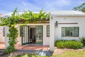 une maison blanche avec une porte verte et des vignes dans l'établissement Koo Karoo Guest Lodge and Self Catering, à Montagu