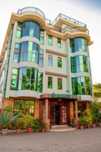 a large building with plants in front of it at Grace Land Hotel in Arusha