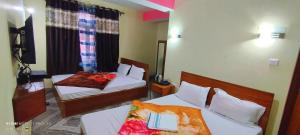 um quarto de hotel com duas camas e um quarto com duas em Hotel Nindik em Gangtok