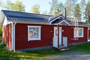 a red house with a white door and windows at Ekokatti Cottages in Vuokatti