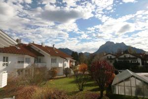 einen Blick auf Häuser in einem Vorort mit Bergen im Hintergrund in der Unterkunft Ferienanlage Neuschwansteinblick Ferienwohnung 106 in Füssen