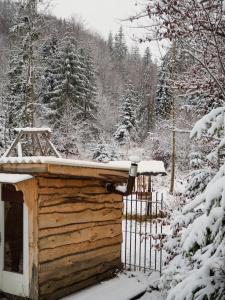 a wooden cabin in the snow with a fence at Rajska Willa in Rajcza