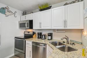 una cocina con armarios blancos y fregadero en Sandpiper Cove 8147 Destin Condo, en Destin
