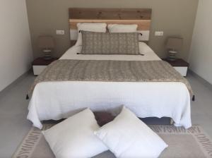 - une chambre dotée d'un grand lit avec des draps et des oreillers blancs dans l'établissement Maison Allies 4p private pool, à Robion