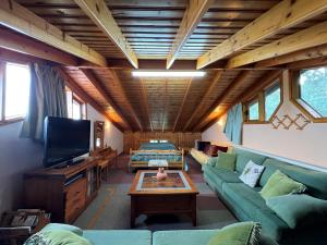 a living room with a couch and a tv at Kapilio Cottage House 