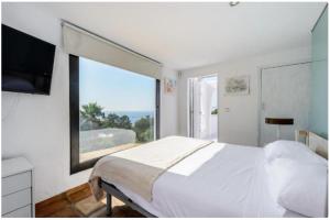 サンアントニオにあるVILLA OVERLOOKING THE SEA+wifi+8p.のベッドルーム(大型ベッド1台、大きな窓付)