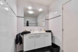 een witte badkamer met een wastafel en een spiegel bij Interbellum in Ieper