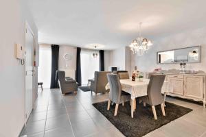 a dining room and living room with a table and chairs at Interbellum in Ypres