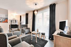 a living room with a couch and a tv at Interbellum in Ieper