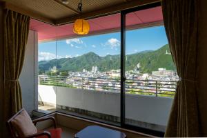 a room with a large window with a view of a city at Kinugawa Grand Hotel Yumenotoki in Nikko