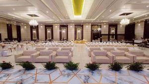 einen großen Bankettsaal mit weißen Stühlen und Tischen in der Unterkunft Hotel Yash Regency in Jaipur