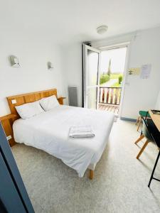 a bedroom with a large white bed and a balcony at Hôtel Rose des Vents in Baix