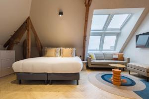 a bedroom with a bed and a living room with a couch at Ocean House Scheveningen in Scheveningen