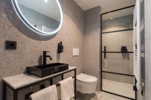 a bathroom with a sink and a toilet and a mirror at Ocean House Scheveningen in Scheveningen