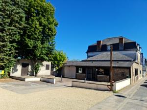 un bâtiment avec un toit noir dans une rue dans l'établissement Coliwork Le Saint Romain, à Dangé