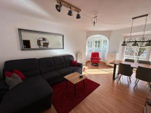 sala de estar con sofá negro y mesa en FeWo Lotti, en Berchtesgaden