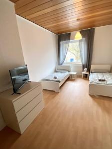 uma sala de estar com duas camas e uma televisão em Core Rooms - Apartment Oberhausen em Oberhausen