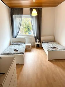 Duas camas num quarto com uma janela em Core Rooms - Apartment Oberhausen em Oberhausen