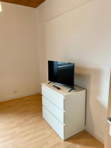 uma sala de estar com televisão numa cómoda branca em Core Rooms - Apartment Oberhausen em Oberhausen