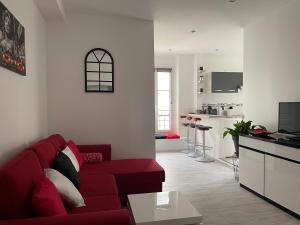 a living room with a red couch and a kitchen at SCI DBSN in Lagny