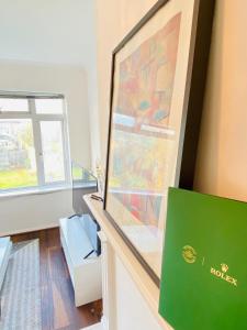 a room with a window and a painting on a wall at Cozy & Quiet Two Bedroom Apartment in Chingford