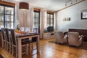 een eetkamer met een tafel en stoelen en een bank bij Break Sokos Hotel Vuokatti in Vuokatti