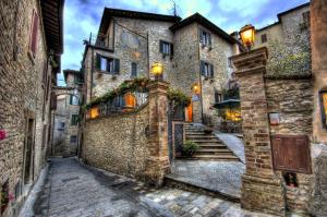 an alley in an old town with stone buildings at La Locanda Del Capitano in Montone