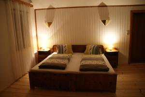 a bedroom with two beds and two lights on the wall at Ferienwohnung Bluntaumühle in Golling an der Salzach