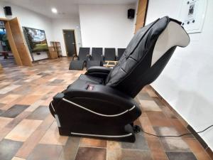 a black leather reclining chair in a room at Apartments Malerič in Dragatuš