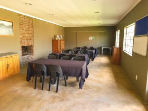 a room with rows of tables and chairs in it at The Outpost Dullstroom in Dullstroom