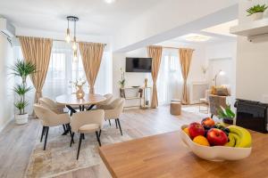 a living room and dining room with a bowl of fruit on a table at Style and view Bucharest city center aparthotel in Bucharest