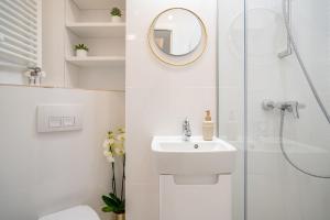 a bathroom with a shower and a sink and a mirror at Style and view Bucharest city center aparthotel in Bucharest