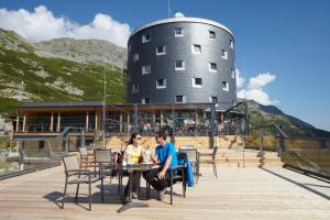 zwei Menschen sitzen an einem Tisch vor einem Silo in der Unterkunft Berghotel Malta in Malta