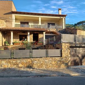 una casa con una pared de piedra y una valla en Apartamento Las Campanitas, en Nuñomoral