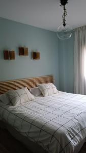 1 dormitorio con 1 cama grande con sábanas blancas en Apartamento Las Campanitas, en Nuñomoral