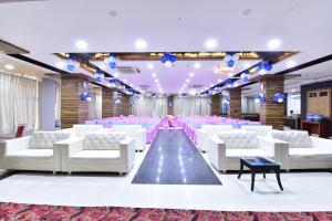 a banquet hall with white chairs and purple lighting at Hotel Signature Prime Vaishali Nagar Jaipur in Jaipur