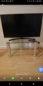 a flat screen tv sitting on top of a glass table at Bright, Spacious, Nice Interior, Close to the City, 2 Bedroom Apartment in London