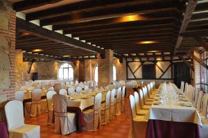 un salón de banquetes con mesas blancas y sillas blancas en Apartamentos El Mirador Del Soto, en Sotoserrano