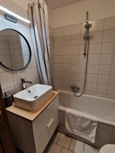 een badkamer met een wastafel, een bad en een spiegel bij City Center Golden Roof 5 in Innsbruck