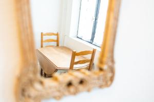 a table and chair in front of a mirror at Le Vieux Pressoir in Dieffenthal