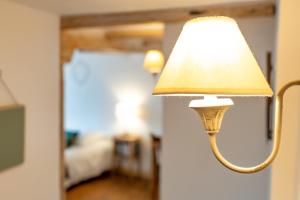 una lámpara pegada a una pared en un dormitorio en Le Vieux Pressoir en Dieffenthal