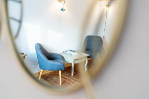 Habitación con 2 sillas azules y mesa. en Le Vieux Pressoir en Dieffenthal