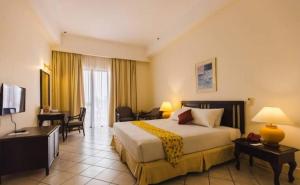 una camera d'albergo con un grande letto e una scrivania di The Orient Star Resort Lumut a Lumut
