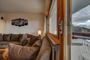 a living room with a couch and a window at Appartement Mont Parrain 14 in La Tzoumaz