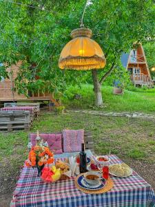 a picnic table with food and an umbrella at Teo's Cottages in Dedoplis Tskaro